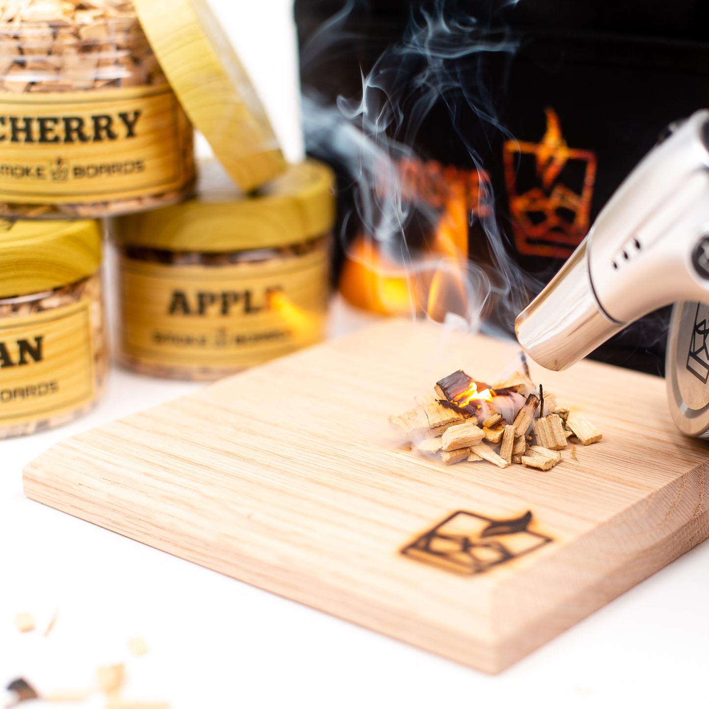 Wooden smoking device with smoke, surrounded by jars labeled 'Cherry' and 'Apple', on a white background. bartender gift for dad