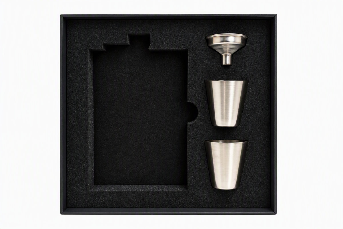Open black gift box with foam insert, two stainless steel shot glasses, and a stainless funnel for the 8 oz hip flask gift set